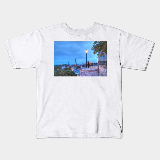 View from Toompea of Lower Town, Old Town with St. Olai's Church or Oleviste Kirik, and the towers of the city wall at dusk, Tallinn, Estonia, Europe Kids T-Shirt by Kruegerfoto